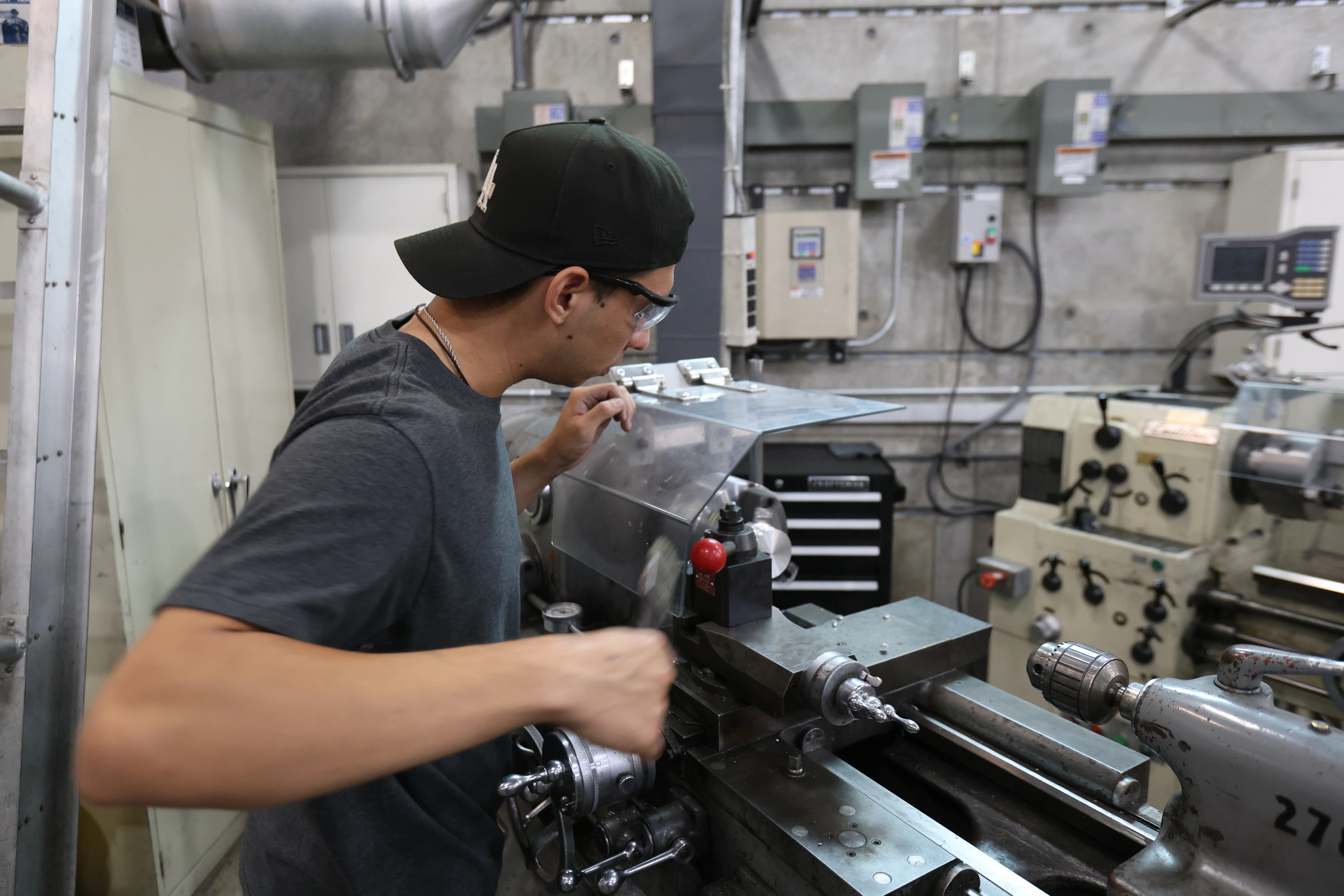 Student machining a part on a lathe