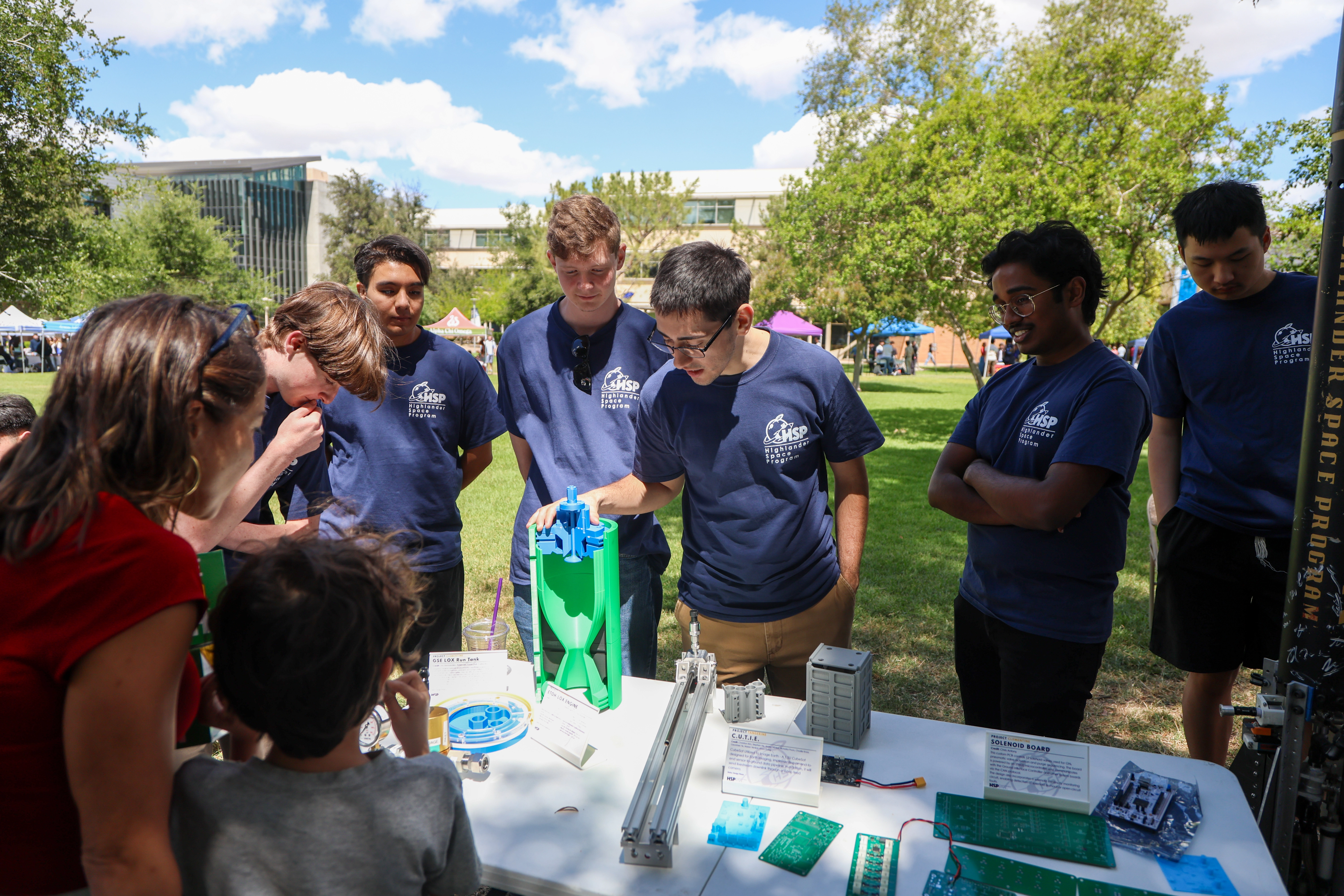 Students discussing rocketry during an outdoor outreach event